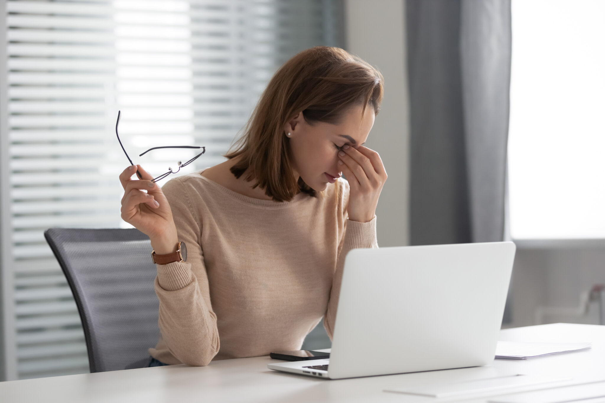 Woman experiencing eye strain before eye exam for glasses